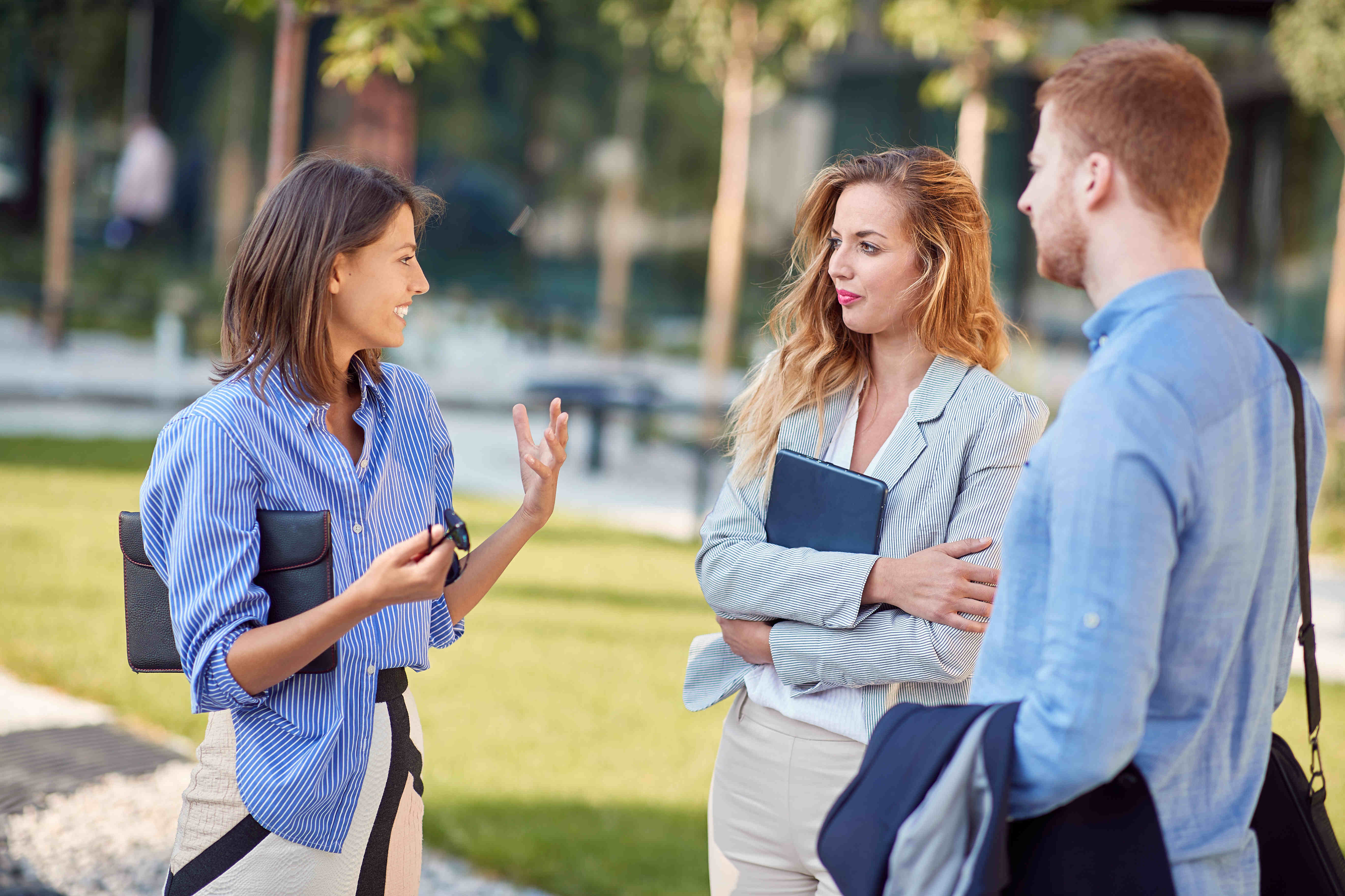 an image of a male and 2 females in business clothes chatting
